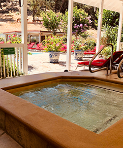 Hot Tub looking out onto the pool. If you're not staying with us, then use one of our day or evening passes